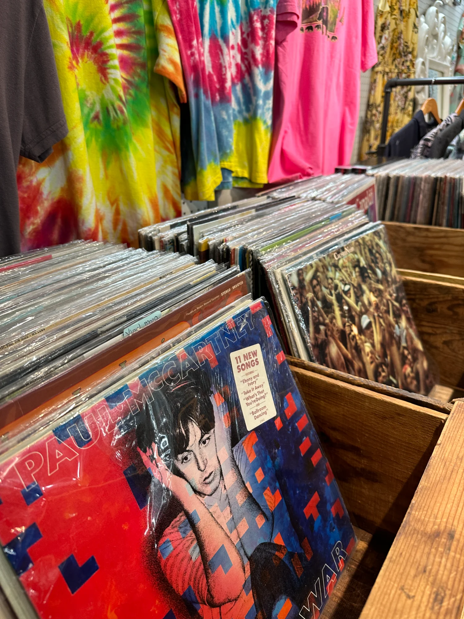 Vintage vinyl record collection with retro clothing in background