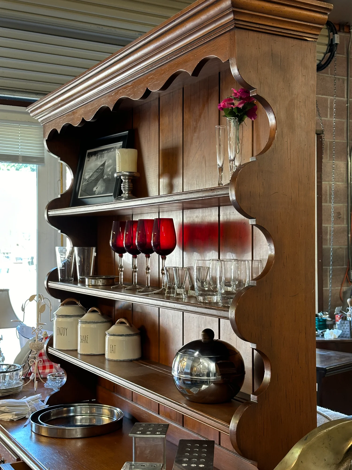 Vintage wooden wall shelf with red glassware and decorative kitchen items